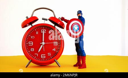 NORWALK, CT, USA - 4 GENNAIO 2023: Orologio rosso con Captain America in piedi su sfondo giallo e bianco Foto Stock