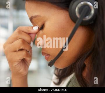 Mal di testa, stress e operatore del call center con depressione, problemi di salute mentale o ansia nel telemarketing, assistente virtuale o supporto alla carriera IT Foto Stock