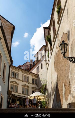 Intorno a Praga, scene di strada con persone, tram ed edifici in una giornata estiva. Foto Stock