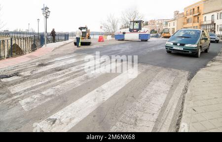 Macchine che eseguono lavori di asfaltatura e pavimentazione su una strada urbana. Foto Stock