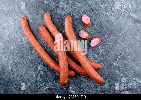 Tradizionale salsiccia di formaggio crudo austriaca con formaggio offerto come vista dall'alto su sfondo grigio con testo libero spazio Foto Stock