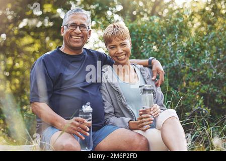 Natura, trekking e ritratto di una coppia anziana riposarsi mentre fare passeggiata all'aperto per l'esercizio fisico. Felice, sorridente e anziano uomo e donna in pensione Foto Stock
