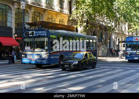 Buenos Aires, Argentina - 20 dicembre 2022: Via Buenos Aires con autobus cittadino e passeggeri sulla strada centrale della città. Trasporto pubblico in Argentina. Turismo, viaggi, vita di strada e attrazioni. Foto di alta qualità Foto Stock