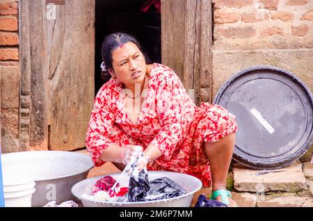 Facce del Nepal: Donna che lavano vestiti Foto Stock