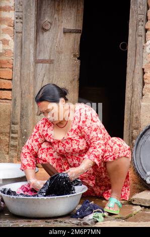 Facce del Nepal: Donna che lavano vestiti Foto Stock