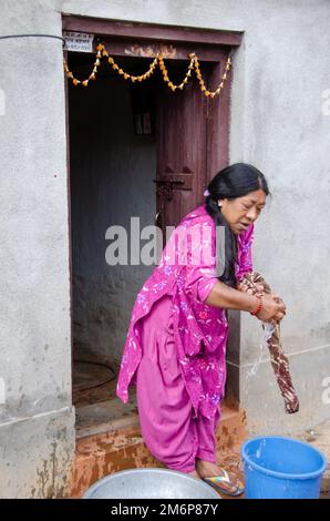 Facce del Nepal: Donna che lavano vestiti Foto Stock