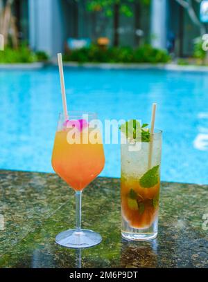 Cocktail d'arancia e mojito in piscina per una vacanza di lusso Foto Stock