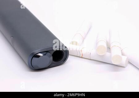 Non brucia moderno scaldabacco elettronico con bastoncini di tabacco su sfondo bianco. Dispositivo di sigaretta elettronica per l'utilizzo di bastoncini da tabacco. Foto Stock