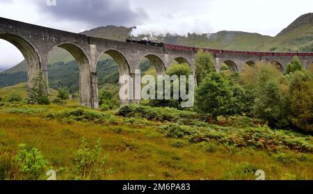 Il treno a vapore Jacobite che attraversa il viadotto di Glenfinnan nelle Highlands scozzesi. Foto Stock