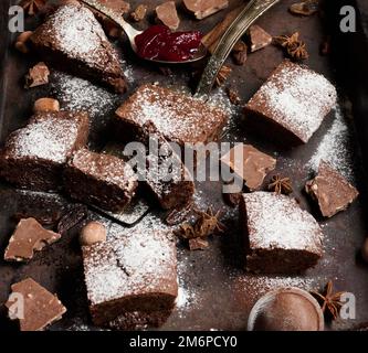 Pezzi quadrati di brownie al cioccolato al forno cosparsi di zucchero a velo Foto Stock