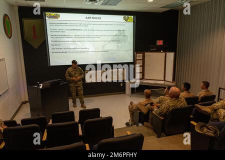 Staff Alex Jobe, comandante del carro armato, Fernando Medina, gunner, Arath Flores, Joshua Kramer, pilota, partecipa a una revisione post-azione con il cadre della Sullivan Cup seguendo le loro condizioni di Table VI al complesso Digital Multi-Purpose Range di Fort Benning, Georgia. Foto Stock