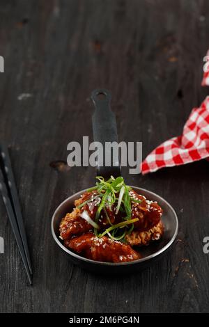 Pollo fritto coreano o Dakgangjeong. Pollo fritto speziato Drumette Wing fritto profondo con salsa piccante rossa. Cucina coreana di stile popolare Foto Stock