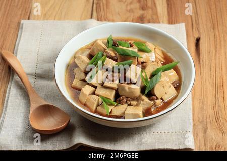 Tofu mapo fatto in casa con carne mince, condimenti con cipolla verde a fette Foto Stock