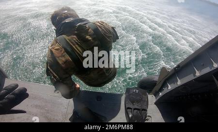 Un Beret Verde assegnato a 2nd battaglione, 10th Special Forces Group (Airborne), lancia da un elicottero UH-60 Black Hawk posizionato vicino a Key West, Florida, il 3 maggio 2022. L'Helocasting, o caduta libera da un elicottero, è stato condotto per familiarizzare il personale delle forze operative speciali con le tecniche di inserimento ed estrazione in un ambiente a base d'acqua spesso utilizzato in ambienti semi- o non-permissivi per rimanere clandestino. (Foto DOD) Foto Stock