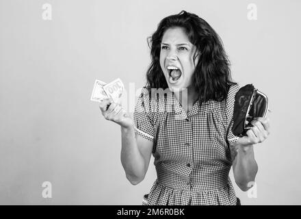 Economia shopaholic. E concetto di crisi. Donna casalinga ha un problema finanziario. Ragazza bisogno di prestito o di credito. Pianificazione del reddito. Donna arrabbiata tenere portafoglio Foto Stock