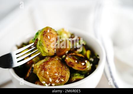 Germogli di Bruxelles di Teriyaki arrosto serviti in una ciotola, fuoco selettivo Foto Stock