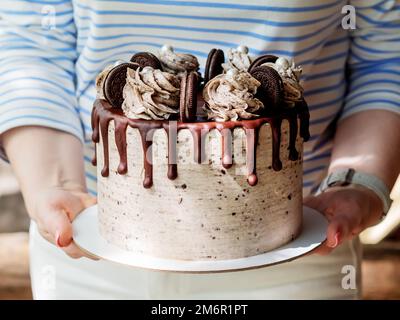 Donna che tiene una bella torta rotonda con cioccolato Foto Stock