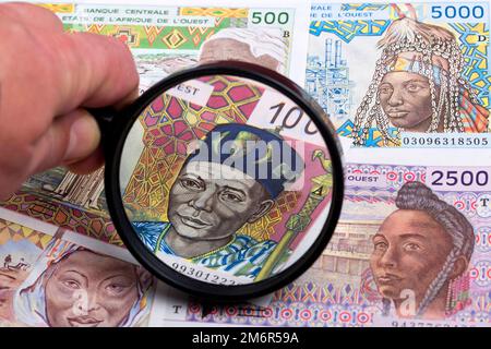 Denaro dell'Africa occidentale in una lente d'ingrandimento Foto Stock