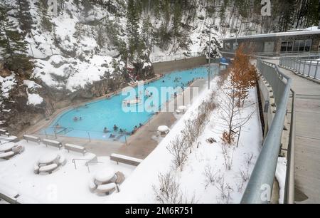 Radium Hot Springs, British Columbia, Canada – 30 gennaio 2022: Le persone si rilassano in una sorgente termale naturale nel Parco Nazionale di Kootenay Foto Stock