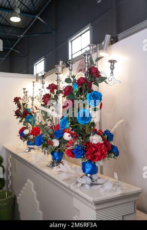 l'arredamento dell'evento con fiori rossi e blu in vasi. Foto Stock