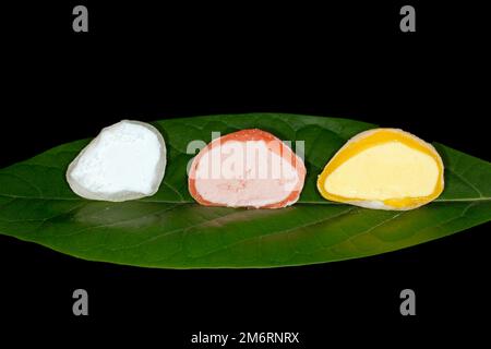 Gelato giapponese mochi ripieno di yuzu, mango e fragola, fotografia alimentare con sfondo nero Foto Stock