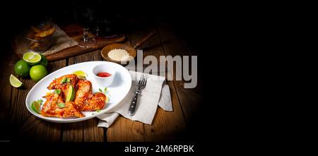 Ali di pollo con spicchi di patate e zam. Foto Stock