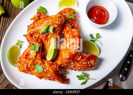 Ali di pollo con spicchi di patate e zam. Foto Stock
