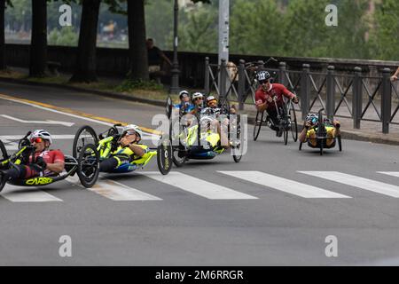 Gruppo di atleti con le loro bici speciali su un percorso cittadino in una corsa. Foto Stock