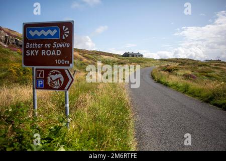 Road Sign in irlandese e inglese sulla famosa Sky Road a Galway, Irlanda Foto Stock