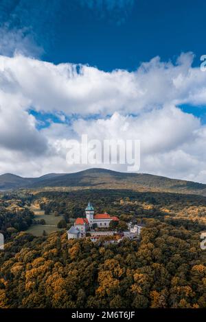 Vista verticale del Castello di Smolenice nei piccoli Carpazi all'inizio dell'autunno con colori fogliari autunnali Foto Stock