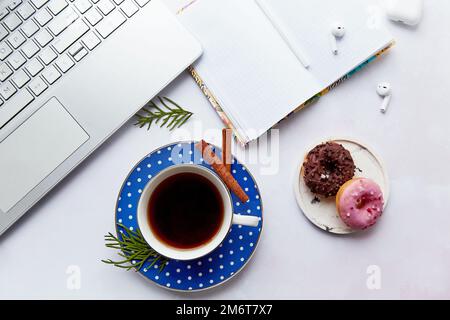 Stile di vita con computer portatile, auricolari wireless, tazza da caffè con ciambelle. Corso online, imparare la lingua, freelance. Webinar, lavoro online, ascolto Foto Stock