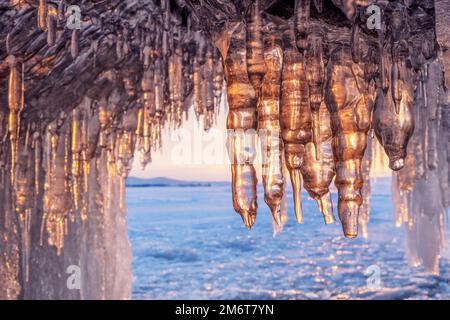 Ghiaccioli in grotta sul lago Baikal al tramonto Foto Stock