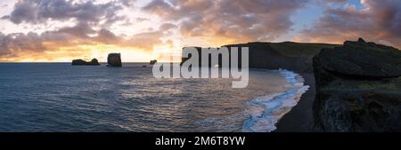 Pittoresca autunno sera vista del Capo Dyrholaey, spiaggia e formazioni rocciose. Vik, Islanda del Sud. Foto Stock