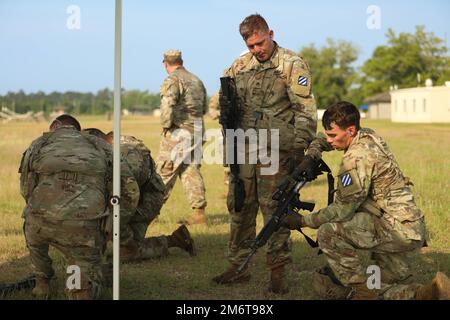 STATI UNITI Personale dell'esercito Sgt. Colby Kuberski e Sgt. Grant Arnall, entrambi i membri dell'equipaggio di carri armati M1A2 SEPv2 Abrams assegnati a 2nd battaglione, 69th reggimento dell'armatura, 2nd squadra di combattimento di Brigate Armorate, 3rd divisione di fanteria, Garantisce che la carbina M4A1 di Grant venga eliminata dalle munizioni durante la fase di tiro sotto stress della Sullivan Cup a Fort Benning, Georgia, 5 maggio 2022. La Sullivan Cup richiede la padronanza dei compiti individuali, la competenza tecnica e tattica, e la capacità di dimostrare una serie di abilità di manovra, di sostegno e di sparatoria. Foto Stock