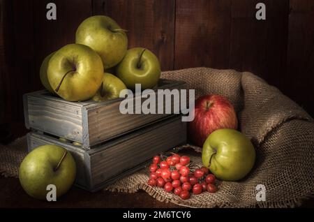 Mele e altri alimenti su sfondo di legno scuro in stile rustico Foto Stock