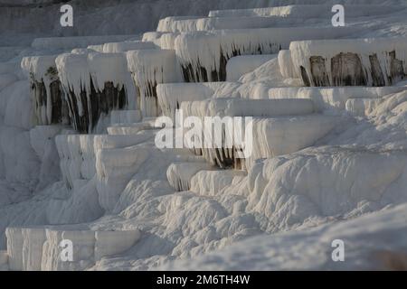 Pamukkale, Turchia. bagni in terrazza cascata, stalattiti di calcite bianca al tramonto, minerale di carbonato lasciato dal flusso di acqua termale di sorgente Foto Stock