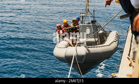 220505-N-TT059-2008 MARE ARABICO (05 maggio 2022) i marinai si imbarcheranno su una barca gonfiabile a scafo rigido mentre viene abbassata durante le operazioni di piccole imbarcazioni nel Mar Arabico, 5 maggio. Momsen è presente nell'area operativa della flotta statunitense 5th per garantire la sicurezza e la stabilità marittima nella regione del Medio Oriente. Foto Stock