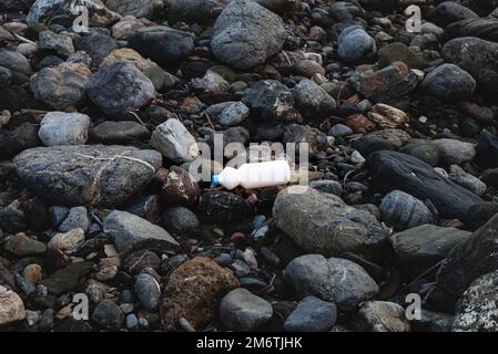 Inquinamento ambientale. Confezione in plastica bianca sulla riva del mare Foto Stock