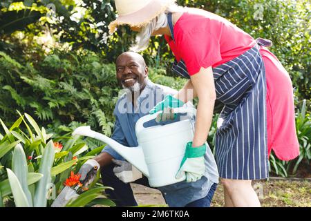 Felice coppia anziana diversa che lavora in giardino Foto Stock