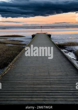 Nuvole tempesta sul lungomare al tramonto Foto Stock