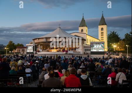 Pellegrini che adorano Gesù Cristo presente nel Santissimo Sacramento dopo la Santa Messa serale a Medjugorje, Bosnia-Erzegovina. Foto Stock