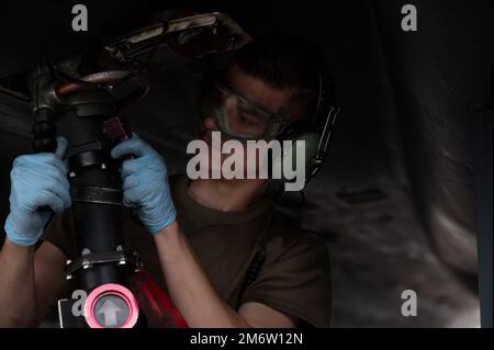 Un Airman assegnato al 334th Fighter Generation Squadron collega un tubo di rifornimento a un F-15E Strike Eagle al Kinston Regional Jetport, Kinston, North Carolina, 5 maggio 2022. Durante l'esercizio, gli Airmen multi-capaci hanno condotto un turno di combattimento integrato in un ambiente austero simulato. Foto Stock