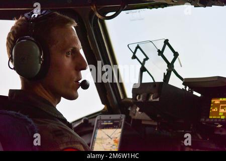 STATI UNITI Christopher Abrahamsen, 535th pilota istruttore di Airlift Squadron, parla con un co-pilota nell'abitacolo di un C-17 Globemaster III durante Exercise Global Dexterity alla base congiunta Pearl Harbor-Hickam, Hawaii, 5 maggio 2022. La 15th Wing ha invitato la Royal Australian Air Force No. 36 Squadron a partecipare a un esercizio bilaterale incentrato sulla C-17 per migliorare l'interoperabilità per le future operazioni Indo-Pacific. Foto Stock