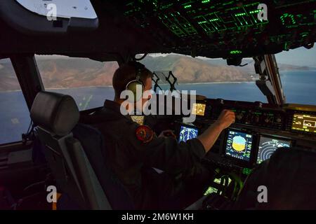 STATI UNITI Christopher Abrahamsen, 535th pilota istruttore di Airlift Squadron, vola un C-17 Globemaster III durante l'esercizio di Dexterity globale alla base congiunta Pearl Harbor-Hickam, Hawaii, 5 maggio 2022. La Royal Australian Air Force si è unita allo Squadrone Airlift 535th per dimostrazioni di flare e manovre aeree di addestramento notturno intorno alle isole Hawaiane per aumentare meglio la resilienza operativa di ogni equipaggio. Foto Stock