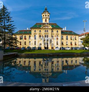 Vista sul municipio di Szeged con riflessi in una piscina fontana Foto Stock