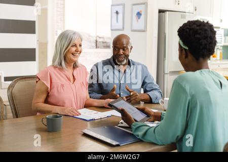 Coppia anziana diversa che parla con la consulente finanziario femminile afro-americana Foto Stock