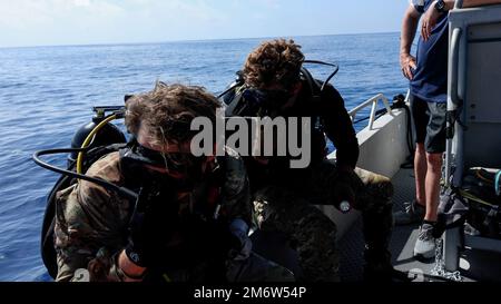 Forze speciali Combat Divers con 10th Special Forces Group (Airborne) preparati ad entrare nell'acqua al largo della costa di Key West, Florida, 5 maggio 2022. Le squadre di immersione delle forze speciali hanno eseguito un'immersione a circuito aperto che ha testato le capacità di ricerca e recupero a una profondità di circa 100 metri come parte di una riqualificazione di tre settimane utilizzata per convalidare le capacità dei subacquei di combattimento. Foto Stock