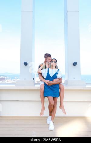 Coppia uomini e donne sul tetto di un hotel di lusso che guarda fuori sullo skyline della città durante le vacanze Foto Stock