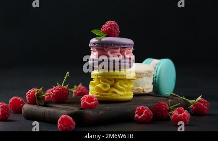 Una pila di macaron multicolore su un asse di legno. Foto Stock