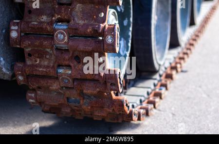 Tracce arrugginite rotte con rulli di un carro armato distrutto. Carro armato russo distrutto durante i combattimenti durante i russi Foto Stock